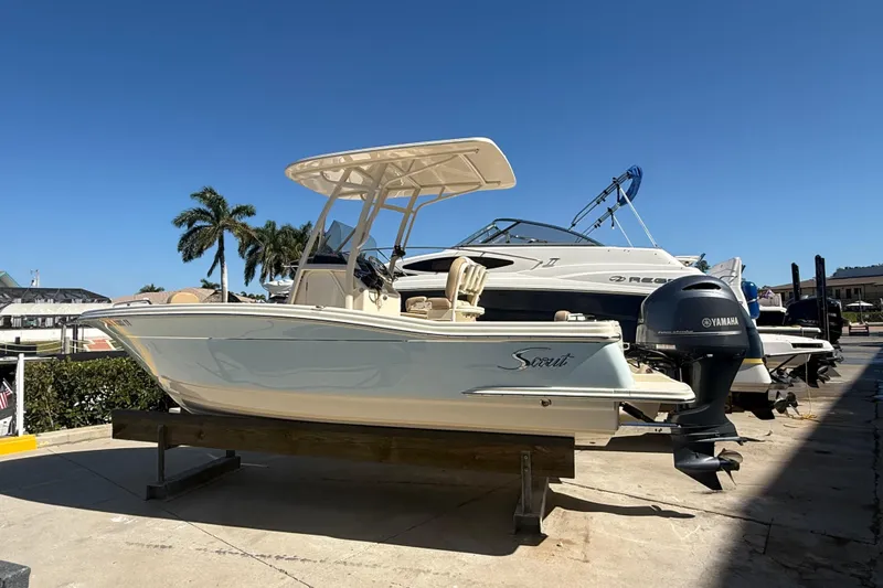 Slide: The Image of 2021 Scout 215 XSF boat with Yamaha engine on display under clear blue sky. - 2