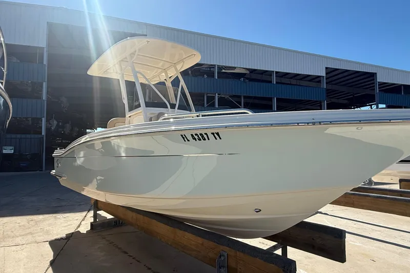 Slide: The Image of 2021 Scout 215 XSF boat on display outside a storage facility under clear blue sky. - 3