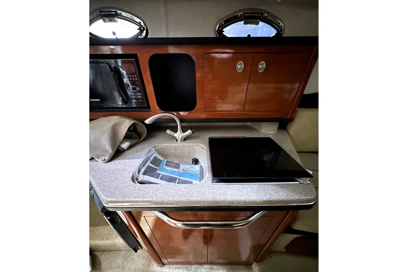 Slide: The Image of 2007 Sea Ray Sundancer 260 cabin kitchen with sink, microwave, and storage cabinets. - 11