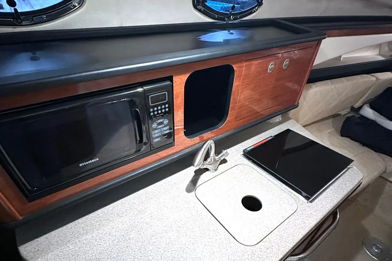 Slide: The Image of 2007 Sea Ray Sundancer 260 interior with microwave, sink, and countertop. - 12