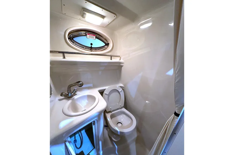 Slide: The Image of 2007 Sea Ray Sundancer 260 bathroom with sink, toilet, and porthole window. - 15