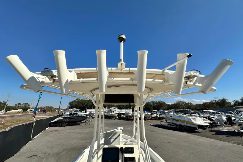 Slide: The Image of 2016 Skeeter SX2250 boat with rod holders, parked in a marina under clear blue sky. - 22