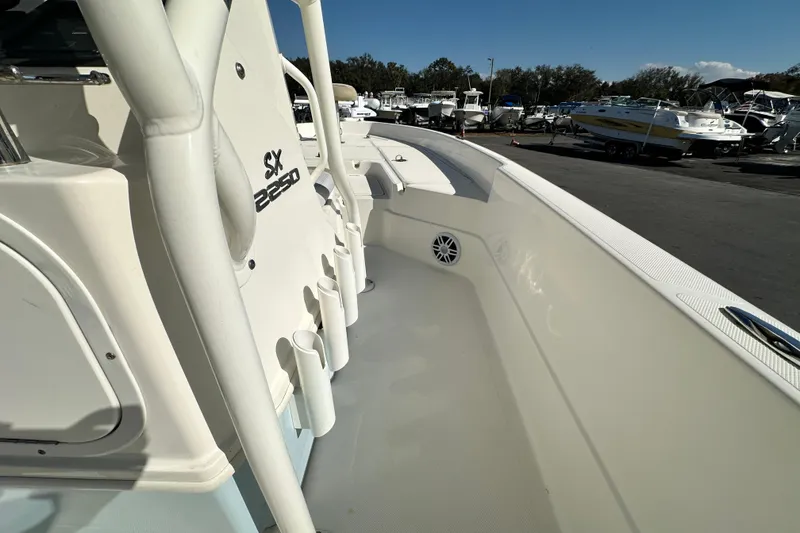 Slide: The Image of 2016 Skeeter SX2250 boat interior with rod holders and seating, docked among other boats. - 41