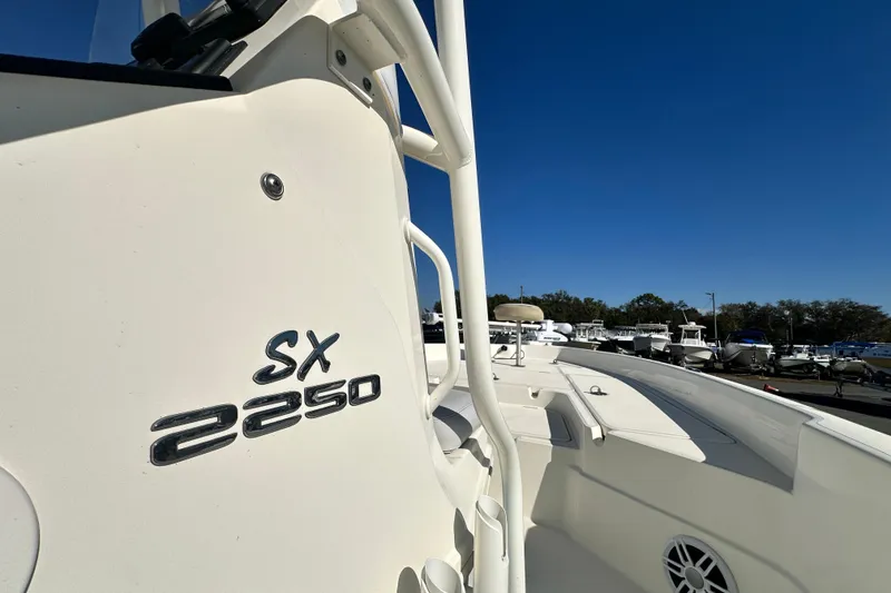 Slide: The Image of 2016 Skeeter SX2250 boat, white exterior, parked in marina under clear blue sky. - 42