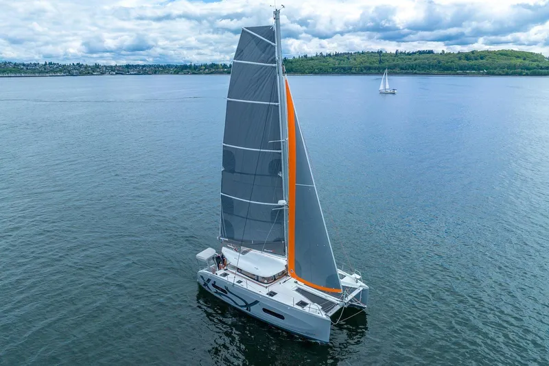 Slide: The Image of Sailing catamaran Excess 11, 2022 model, gliding on calm waters under a cloudy sky. - 0