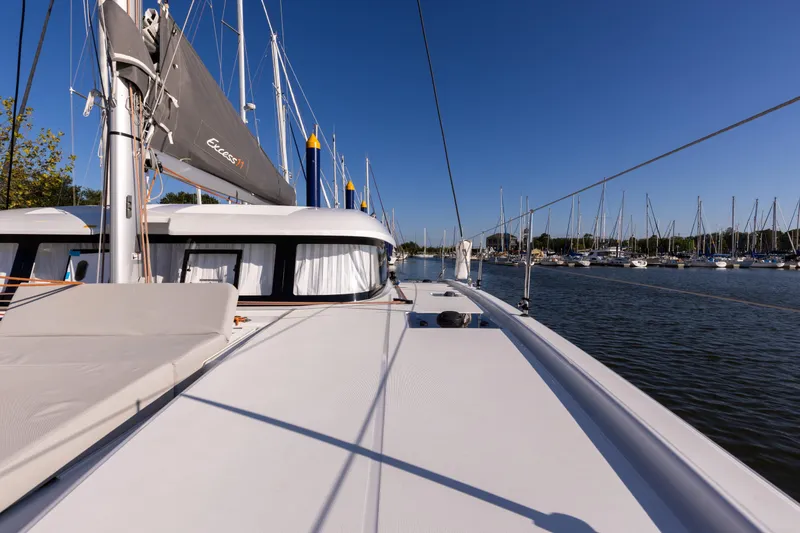 Slide: The Image of 2022 Excess 11 catamaran docked in a marina under clear blue skies. - 16
