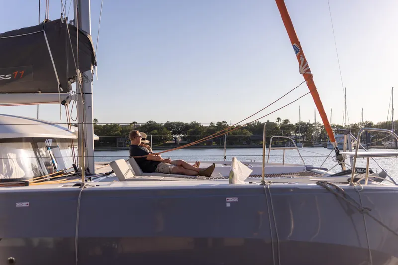 Slide: The Image of Man relaxing on 2022 Excess 11 sailboat, enjoying a sunny day on the water. - 3