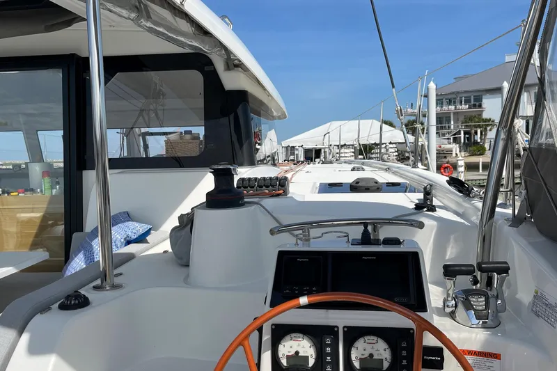 Slide: The Image of Cockpit view of 2022 Excess 11 catamaran docked at marina under clear blue sky. - 34