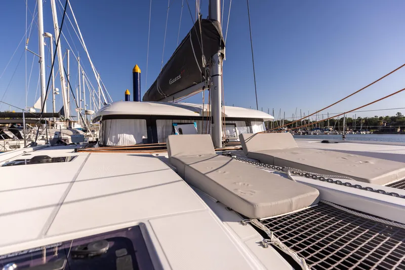 Slide: The Image of Luxurious 2022 Excess 11 catamaran with sunbathing area, docked in a marina under clear blue skies. - 38