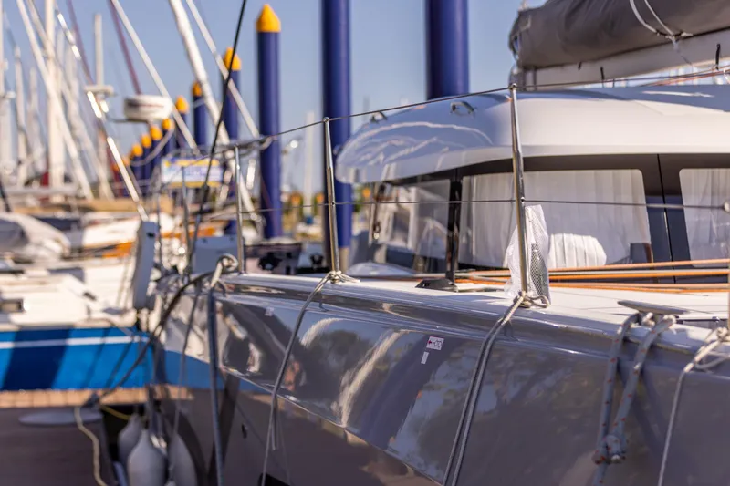 Slide: The Image of Luxurious 2022 Excess 11 catamaran with sunbathing area, docked in a marina under clear blue skies. - 39