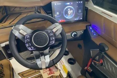 Slide: The Image of 2026 Tigé Ultré 25ZX boat interior with advanced steering wheel and touchscreen display. - 10