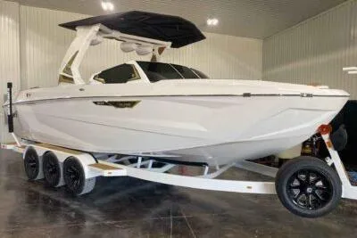 Slide: The Image of 2026 Tigé Ultré 25ZX boat on trailer in indoor showroom. - 2