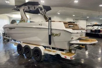 Slide: The Image of 2026 Tigé Ultré 25ZX boat on trailer in showroom, featuring sleek design and modern amenities. - 6