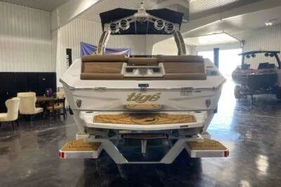 Slide: The Image of 2026 Tigé Ultré 25ZX boat in showroom, rear view with seating and swim platform. - 7
