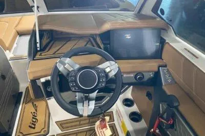Slide: The Image of 2026 Tigé Ultré 25ZX boat interior with modern steering wheel and dashboard controls. - 9