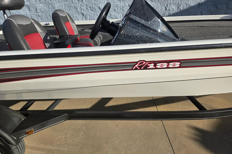 Slide: The Image of 2017 Ranger RT188 boat with red and gray seats, parked on a trailer. - 3