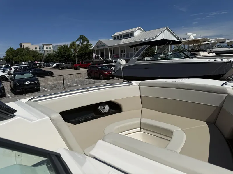 Slide: The Image of Boston Whaler 240 Vantage 2026: Spacious bow area with beige upholstery, parked outdoors. - 18