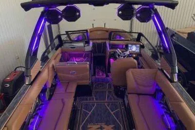 Slide: The Image of 2025 Tigé Ultré 25ZX boat interior with purple LED lighting and luxurious seating. - 3