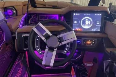 Slide: The Image of 2025 Tigé Ultré 25ZX boat interior with illuminated dashboard and modern steering wheel. - 4