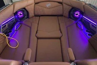 Slide: The Image of 2025 Tigé Ultré 25ZX boat interior with brown seating and purple LED lighting. - 5