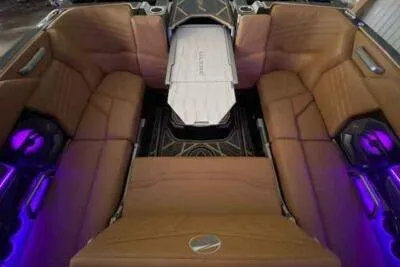 Slide: The Image of 2025 Tigé Ultré 25ZX boat interior with luxurious seating and ambient purple lighting. - 6