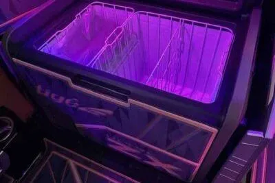 Slide: The Image of 2025 Tigé Ultré 25ZX boat interior with illuminated storage compartment in purple lighting. - 7