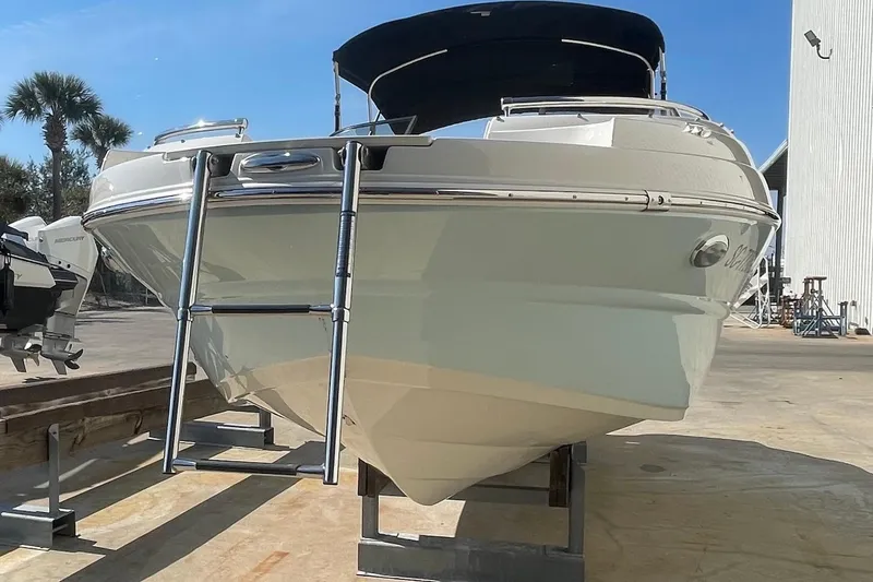Slide: The Image of 2020 Stingray 231 DC boat with ladder, docked under clear blue sky. - 4