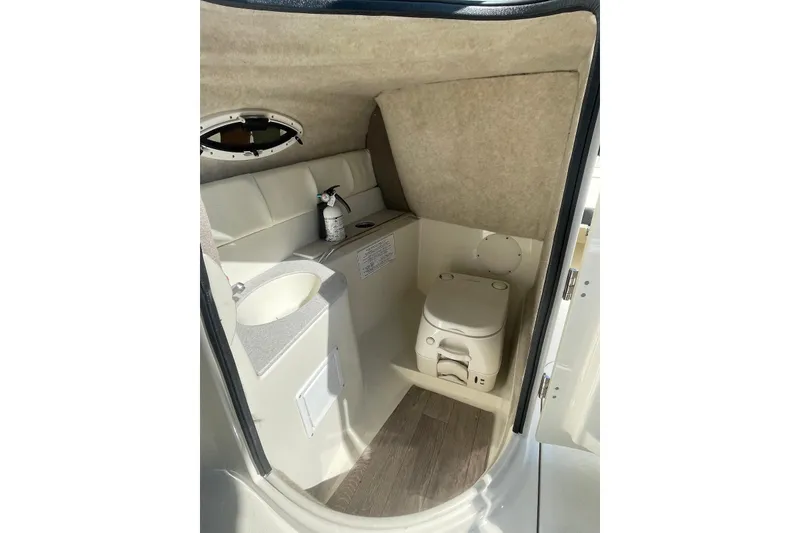 Slide: The Image of 2020 Stingray 231 DC boat interior with compact bathroom and sink. - 7