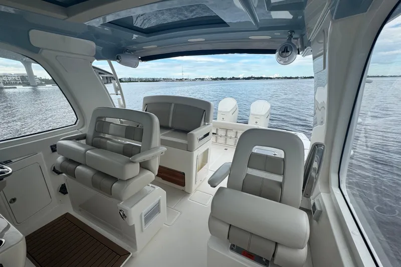Slide: The Image of Interior view of 2018 Boston Whaler 380 Realm boat with luxurious seating and water backdrop. - 11