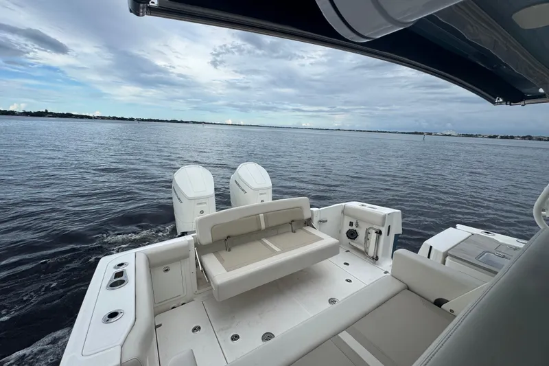 Slide: The Image of 2023 Boston Whaler 380 Realm boat on calm waters, showcasing spacious deck and dual engines. - 5