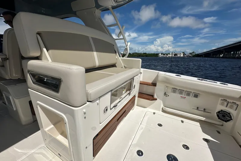 Slide: The Image of 2023 Boston Whaler 380 Realm interior with seating, overlooking water and bridge. - 7