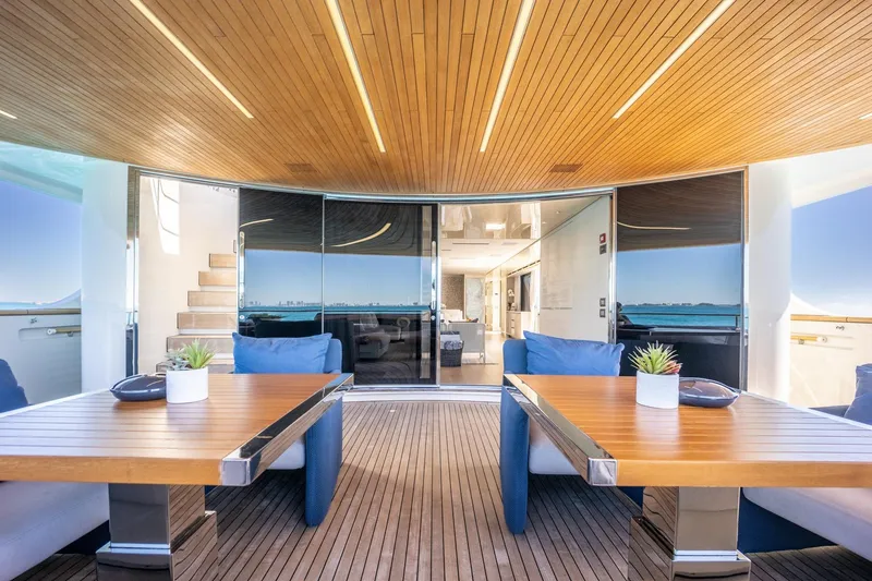 Slide: The Image of Luxurious 2019 Sanlorenzo SD112 yacht deck with wooden tables and plush seating. - 10