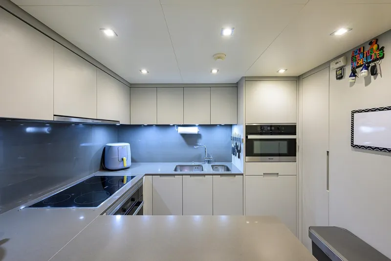 Slide: The Image of Modern kitchen interior on 2019 Sanlorenzo SD112 yacht, featuring sleek cabinetry and appliances. - 24