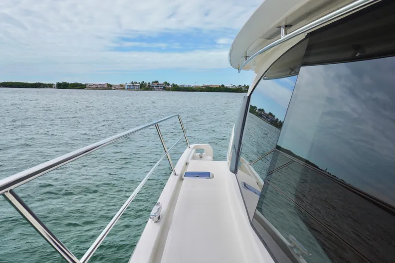 Slide: The Image of 2017 Aquila 44 Yacht cruising on calm waters with scenic shoreline view. - 11