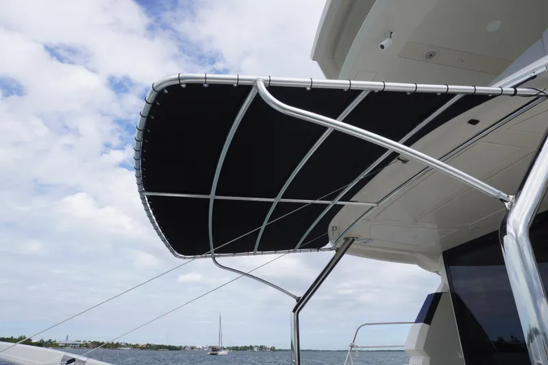 Slide: The Image of Aquila 44 Yacht 2017 with sleek black canopy against a cloudy sky. - 14