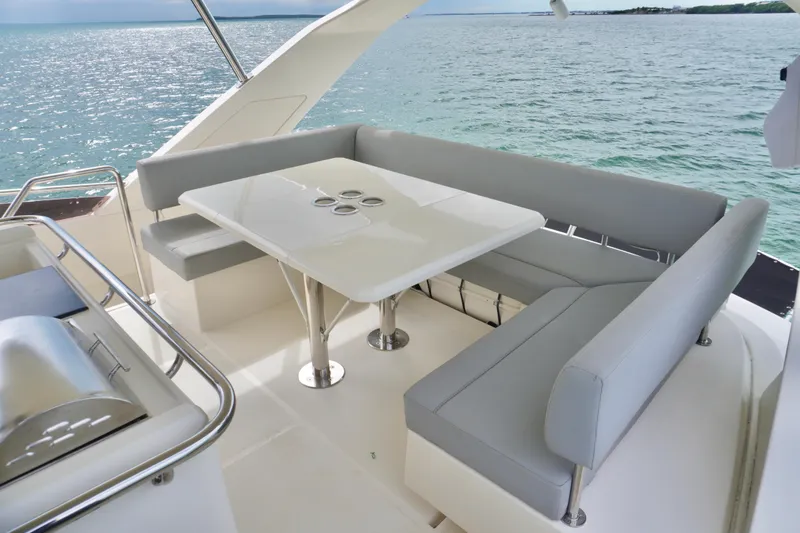Slide: The Image of 2017 Aquila 44 Yacht with elegant outdoor seating and table, overlooking serene ocean waters. - 18