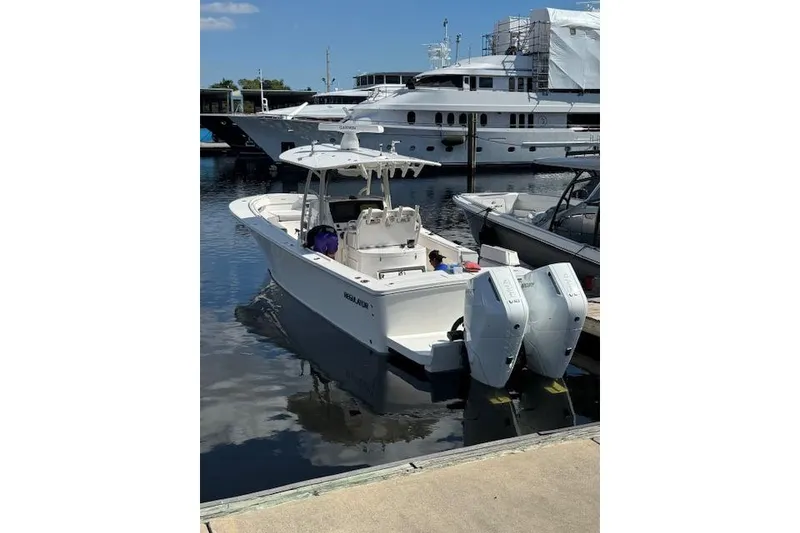 The Image of 2018 Regulator 34 Center Console boat docked at marina with twin engines. - 0
