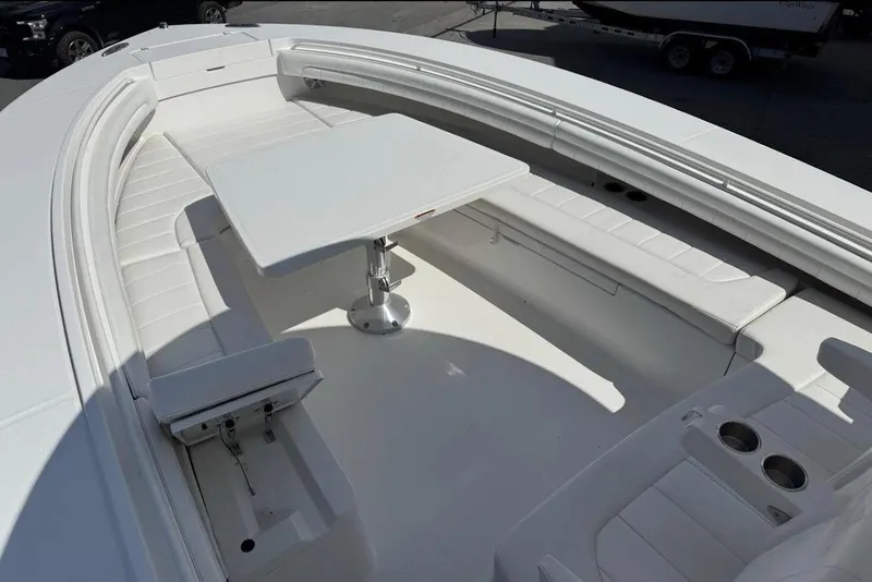 Slide: The Image of 2018 Regulator 34 Center Console boat with spacious seating and table setup. - 12