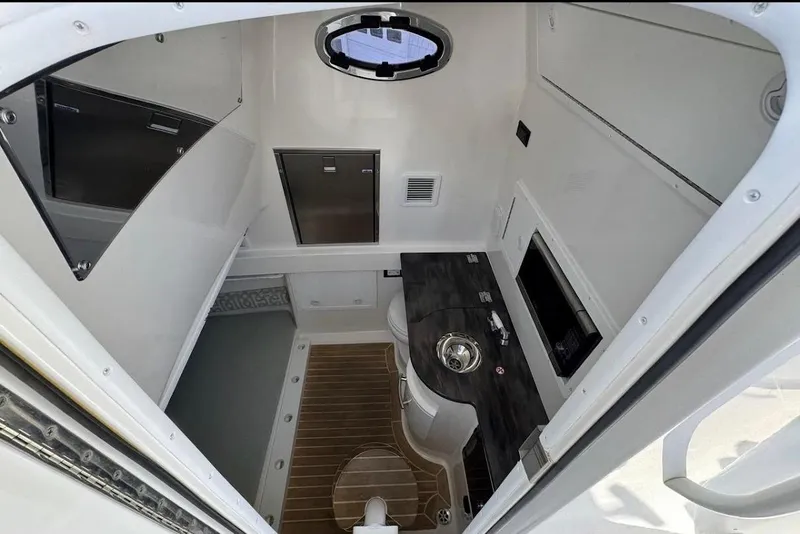 Slide: The Image of 2018 Regulator 34 Center Console cabin interior with sink and storage compartments. - 18