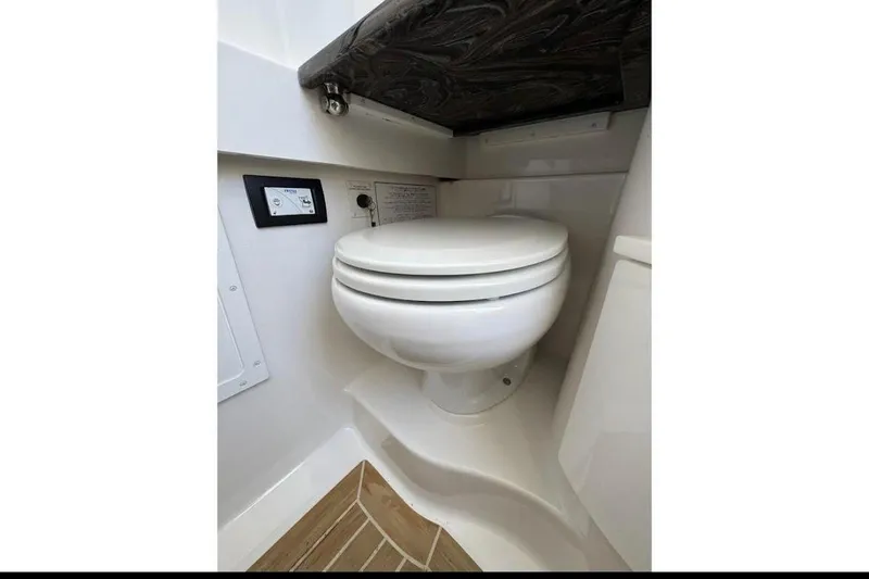 Slide: The Image of 2018 Regulator 34 Center Console boat toilet interior with control panel. - 19
