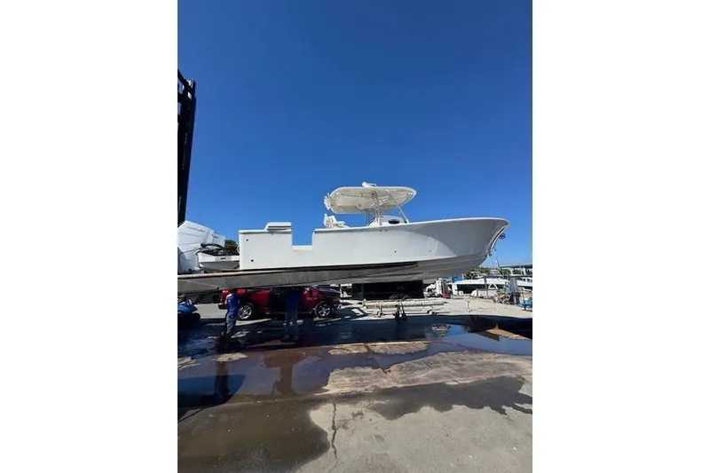 Slide: The Image of 2018 Regulator 34 Center Console boat on a lift under clear blue sky. - 2