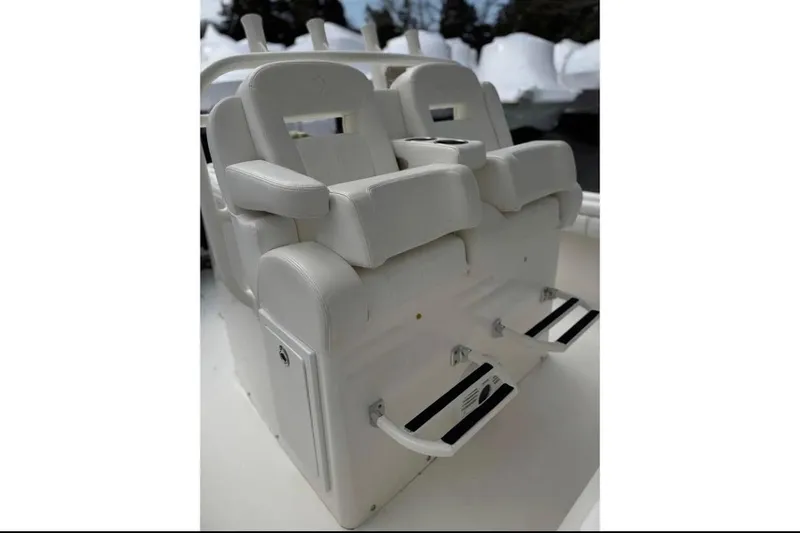 Slide: The Image of 2018 Regulator 34 Center Console boat seating with white cushioned chairs and footrests. - 23