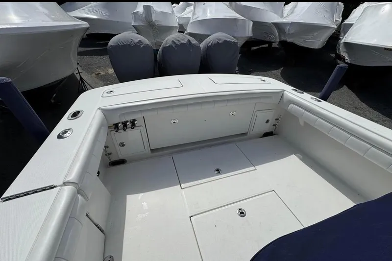 Slide: The Image of 2018 Regulator 34 Center Console boat interior with storage compartments and covered engines. - 24
