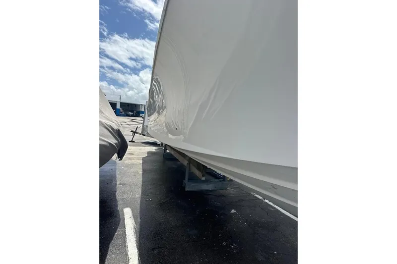 Slide: The Image of 2018 Regulator 34 Center Console boat hull in a sunny outdoor setting. - 26