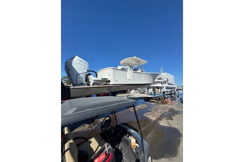 Slide: The Image of 2018 Regulator 34 Center Console boat on trailer at marina under clear blue sky. - 3
