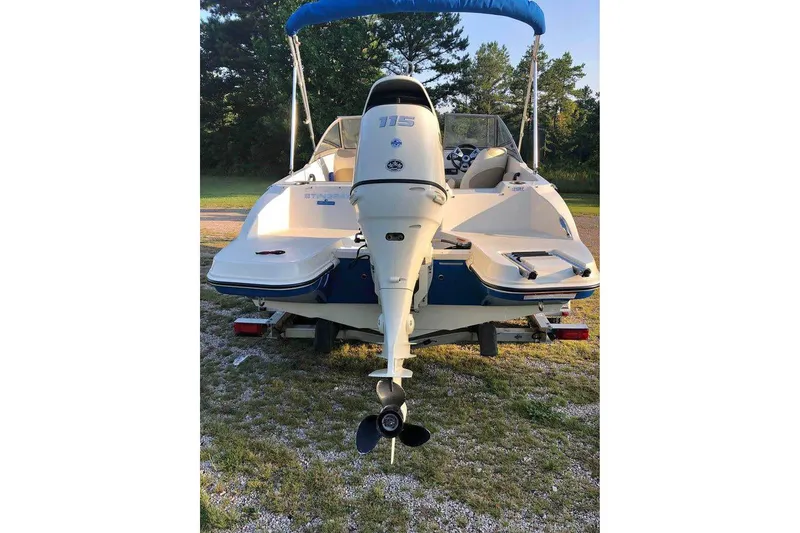 Slide: The Image of 2019 Stingray 191 LX boat with outboard motor, parked on grass. - 10