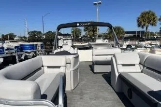 Slide: The Image of 2022 Godfrey Sweetwater 2286 C pontoon boat with spacious seating and canopy, docked under clear skies. - 7