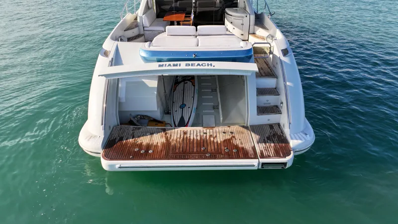 Slide: The Image of Azimut 68S 2006 yacht with open swim platform and surfboard, floating on clear water. - 12