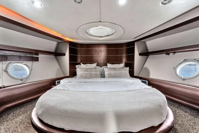 Slide: The Image of Luxurious bedroom interior of 2006 Azimut 68S yacht with elegant design and porthole windows. - 52