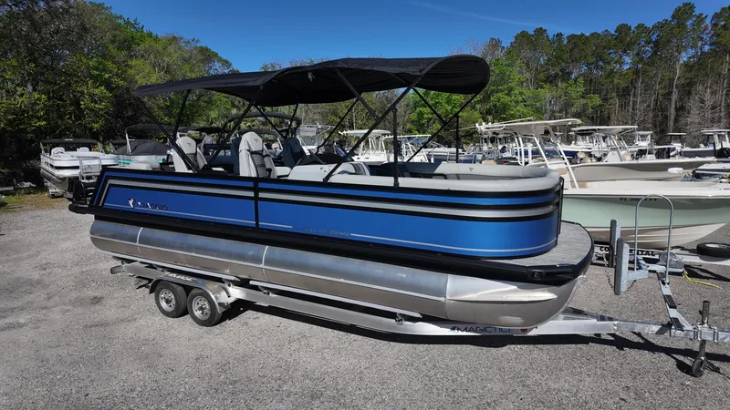 The Image of 2025 Viaggio Z24Q pontoon boat on trailer, blue and silver, parked outdoors. - 0